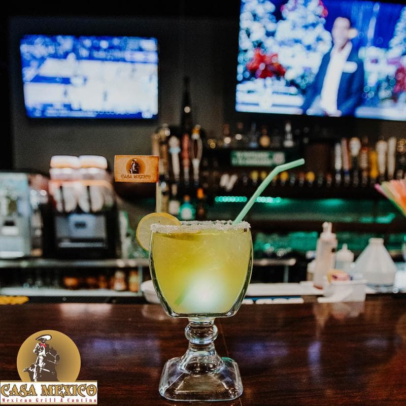 Margarita cocktail, bar area and TVs in the background
